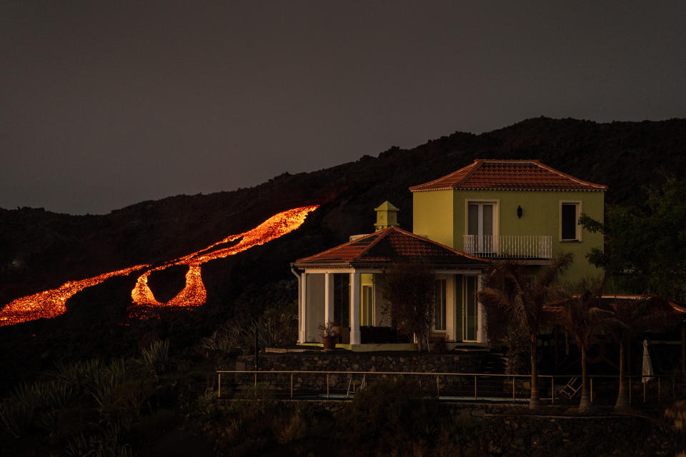 Lava flows from a volcano as it continues to erupt on the Canary island of La Palma, Spain Spain, Monday, Nov. 1, 2021. A volcano on the Spanish island of La Palma that has been erupting for six weeks has spewed more ash from its main mouth a day after producing its strongest earthquake to date. (AP Photo/Emilio Morenatti)