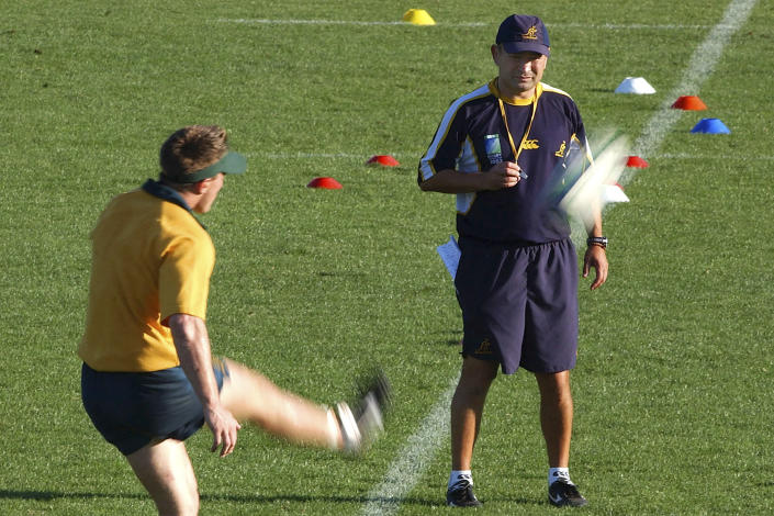 FILE - Australian rugby team head coach Eddie Jones, right, watches as Elton Flatley kicks the ball during a training session in Coffs Harbour, Australia, Nov. 19, 2003. Rugby Australia said Monday, Jan. 16, 2023, it has hired Jones to be the head coach of the Wallabies and that current head coach Dave Rennie "will depart the position." (AP Photo/Rick Rycroft, File)