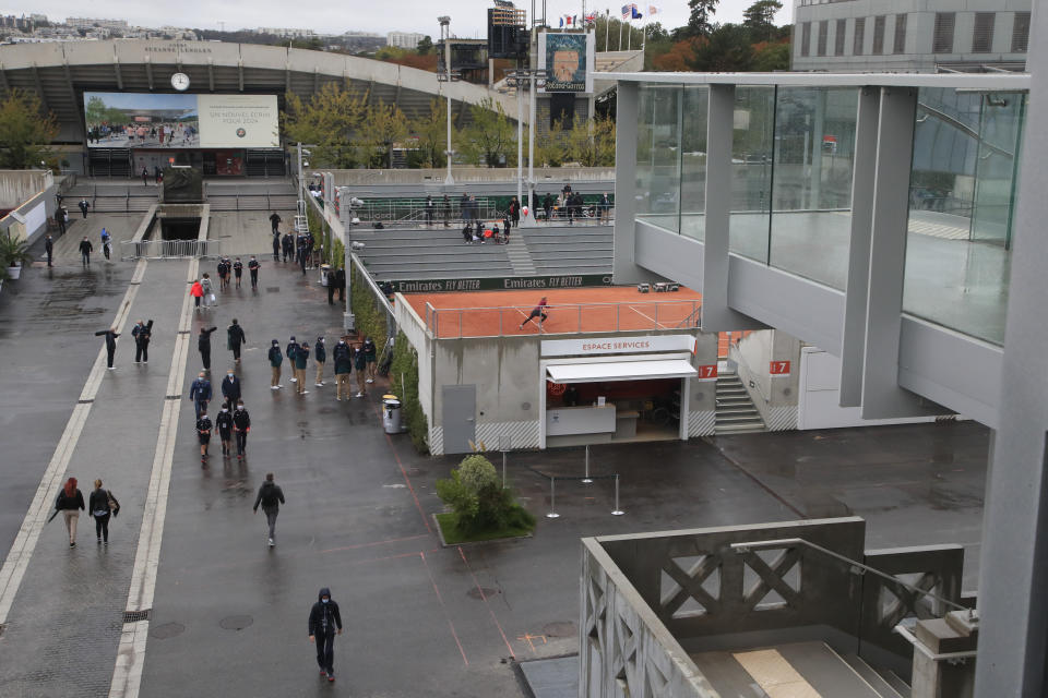 Un puñado de aficionados se desplazan en el complejo del Abierto de Francia, el domingo 27 de septiembre de 2020, en París. (AP Foto/Michel Euler)