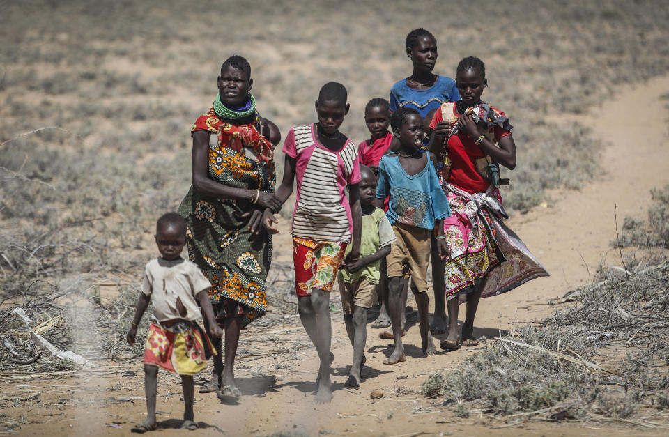 Villagers walk back from a trading center towards their village of Lomoputh in northern Kenya Thursday, May 12, 2022. United Nations Under-Secretary-General for Humanitarian Affairs Martin Griffiths visited the area on Thursday to see the effects of the drought which the U.N. says is a severe climate-induced humanitarian emergency in the Horn of Africa. (AP Photo/Brian Inganga)