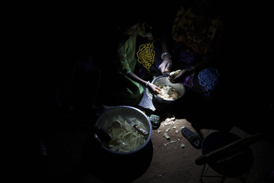 A woman prepares food during the holy month of Ramadan at a compound of a family of herders in the village of Anndiare, in the Matam region of Senegal, Wednesday, April 12, 2023. (AP Photo/Leo Correa)