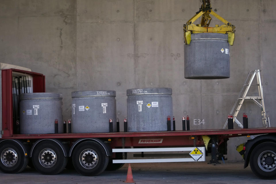 Radioactive waste storage is lifted from a truck in a concrete-sealed warehouse in the Aube region of eastern France managed by French radioactive waste management agency Andra, in Soulaines-Dhuys, Friday, Oct. 29, 2021. Deep in a French forest of oaks, birches and pines, a steady stream of trucks carries a silent reminder of nuclear energy’s often invisible cost: canisters of radioactive waste, heading into storage for the next 300 years. (AP Photo/Francois Mori)