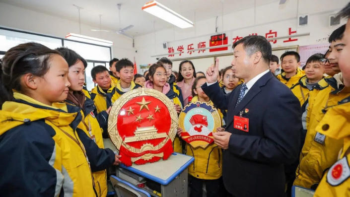 Geng Huaiqing, a deputy to the National People's Congress, explains the "two sessions" to students in Huaian district, Huai 'an City, East China's Jiangsu Province, March 3, 2023.