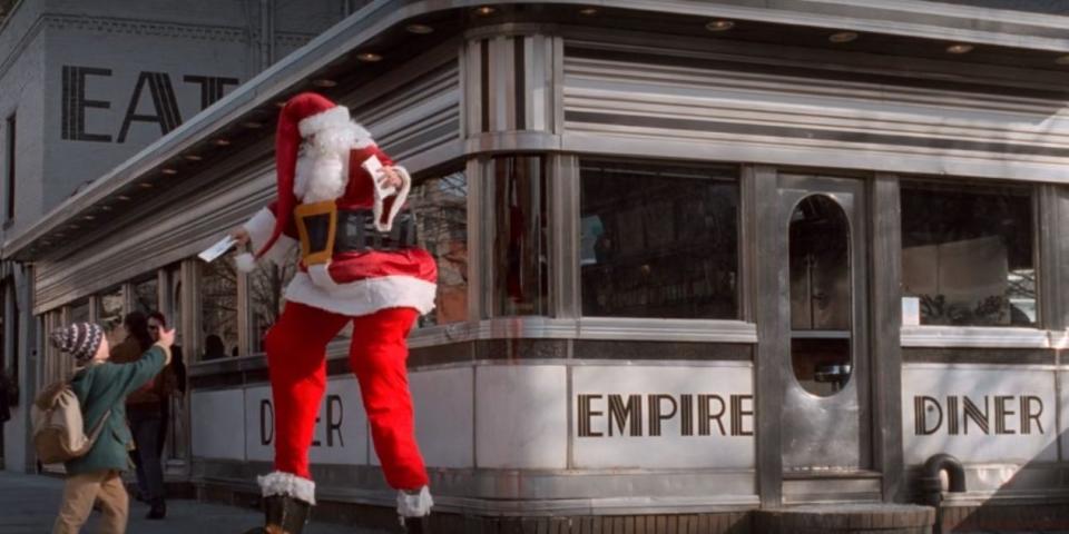 kevin greeting a stilt-walking santa in front of empire diner in new york in home alone 2