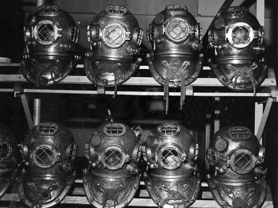 Diving helmets stacked on a shelf at the US Navy Salvage School in New Jersey in 1955.