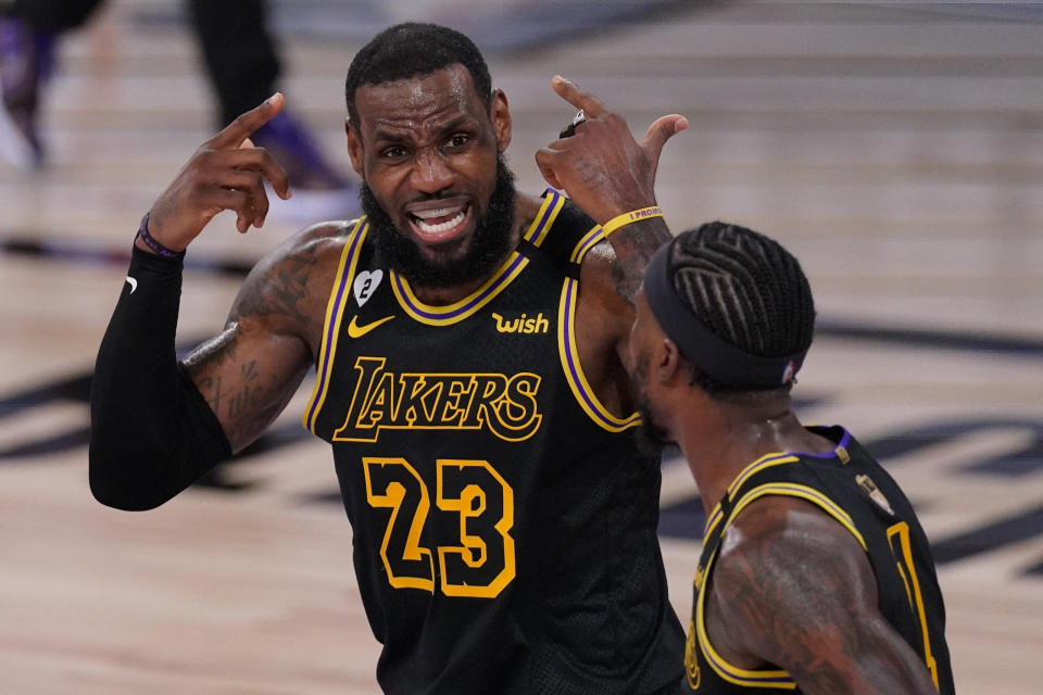 Los Angeles Lakers forward LeBron James talks with guard Kentavious Caldwell-Pope during the first half in Game 5 of basketball's NBA Finals against the Miami Heat Friday, Oct. 9, 2020, in Lake Buena Vista, Fla. (AP Photo/Mark J. Terrill)