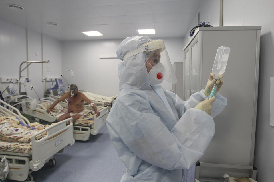 A medical worker prepares to treat a patient infected with COVID-19 at the intensive care unit of a hospital in Nizhny Novgorod, Russia, Monday, Dec. 21, 2020. Russia has reported 29,350 new coronavirus cases, the country's biggest daily surge. Russia's total of over 2.8 million confirmed cases remains the fourth largest in the world. The state coronavirus task force has also reported over 51,000 deaths. (AP Photo/Roman Yarovitcyn)