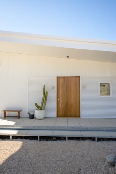 Julie had the front door custom-made of wood and set on a pivot, so that it would be a textural focal point on either side of its opening.