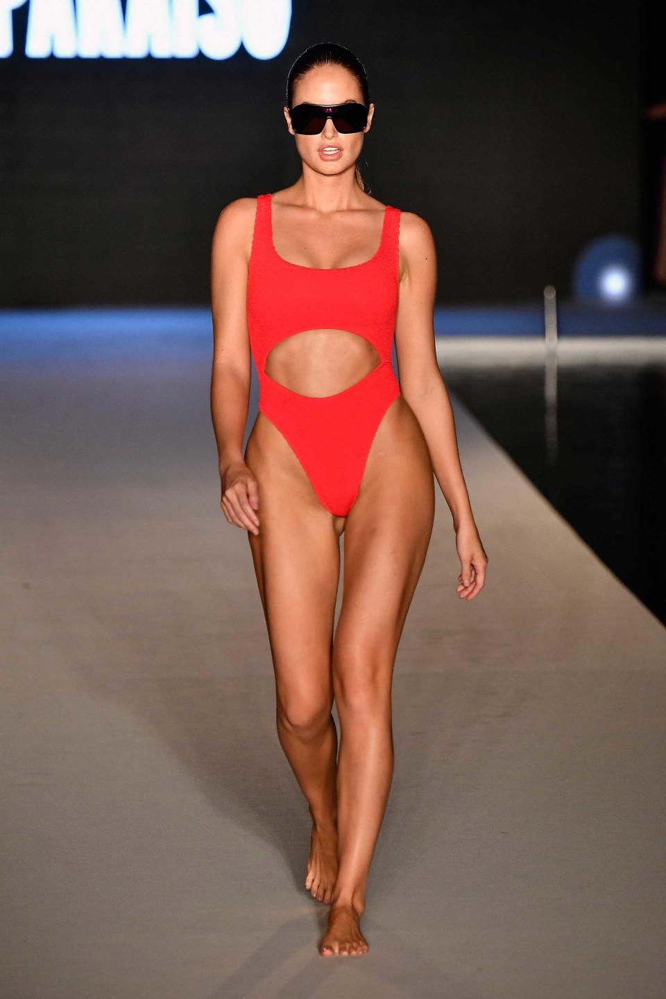 <p>A model walks the runway wearing a red cutout swimsuit for the 2018 <em>Sports Illustrated</em> swimsuit show during the Paraiso Fashion Fair in Miami at the W South Beach hotel on July 15. (Photo: Alexander Tamargo/Getty Images for Sports Illustrated) </p>
