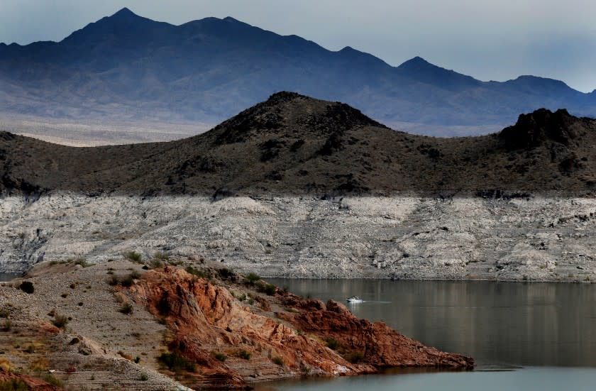 LAKE MEAD, NEV. - JUNE 11, 2021. A boat navigates Lake Mead, where a white "bathtub ring" along the shore shows how far below capacity the nation's largest reservoir currently is. Water levels at Lake Mead have hit their lowest points in history amid an ongoing megadrought, creating uncertainty about the water supply for millions of people in the western United States. (Luis Sinco / Los Angeles Times)