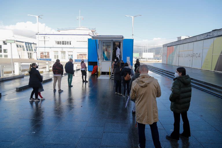 Varias personas hacen cola para hacerse PCR, en un punto móvil de PCR gratuitas en el Naútico de Vigo, en Galicia 