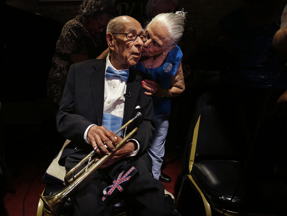 Venerable Dixieland jazz musician Lionel Ferbos receives a kiss from Gladys E. Cheri, 86, who was a flower girl in his wedding, at his 102nd birthday party at the Palm Court Jazz Cafe in New Orleans, Wednesday, July 17, 2013. Ferbos, who bought his first cornet at Rampart Street pawn shop when he was 15, is believed to be the oldest actively working musician in the city. His body isn’t without signs of age. He’s been in and out of the hospital in recent years and had a pacemaker implanted last year. He sometimes uses a wheelchair to get around, but he remains determined to sing and blow. AP Photo/Gerald Herbert)