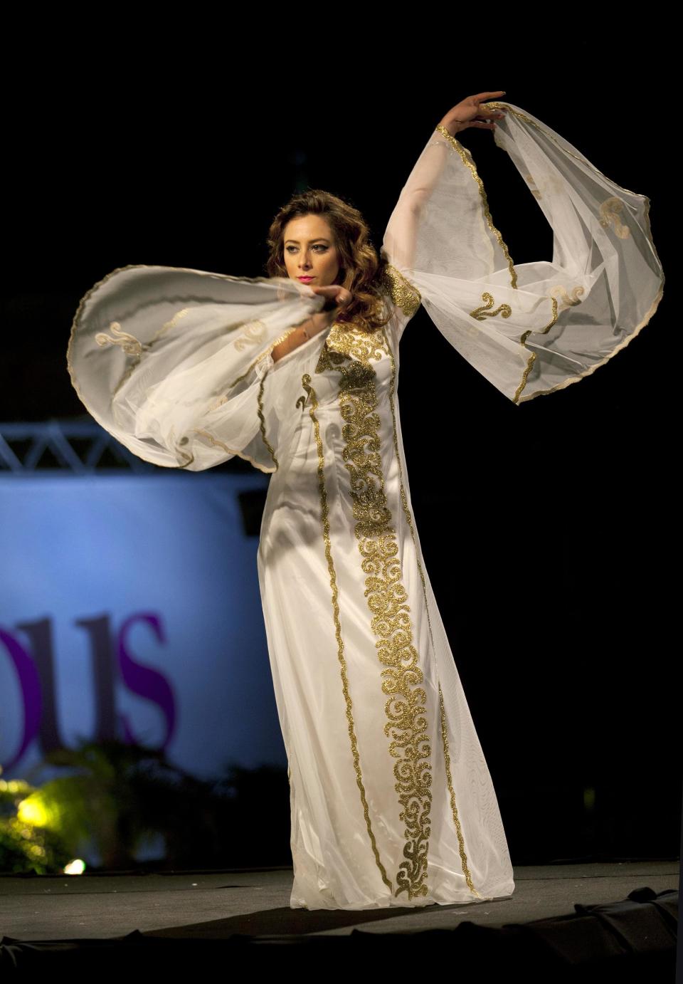 In this photo taken Friday, May 2, 2014, a model displays a creation by designer Intisar Abdo during the second day of the Palestine Fashion Week 2014, in the West Bank city of Ramallah. The collections showed a blend of traditional Palestinian embroidery and modern designs. (AP Photo/Nasser Nasser)