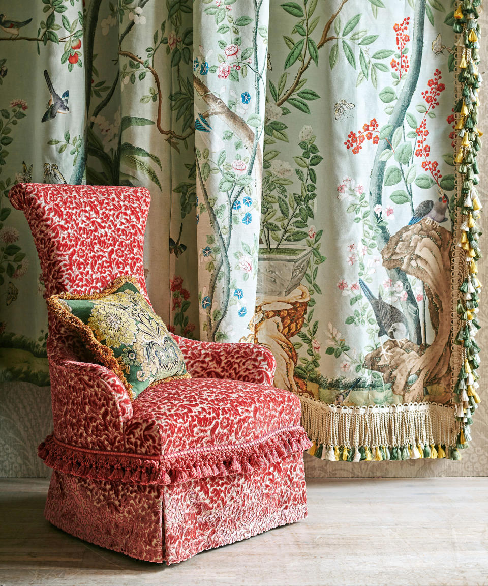 Red patterned chair with fringe, floral curtains with fringe