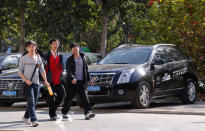 FILE PHOTO - People walk past Cadillac cars outside a dealership in Beijing, October 31, 2012. REUTERS/Petar Kujundzic/File Photo