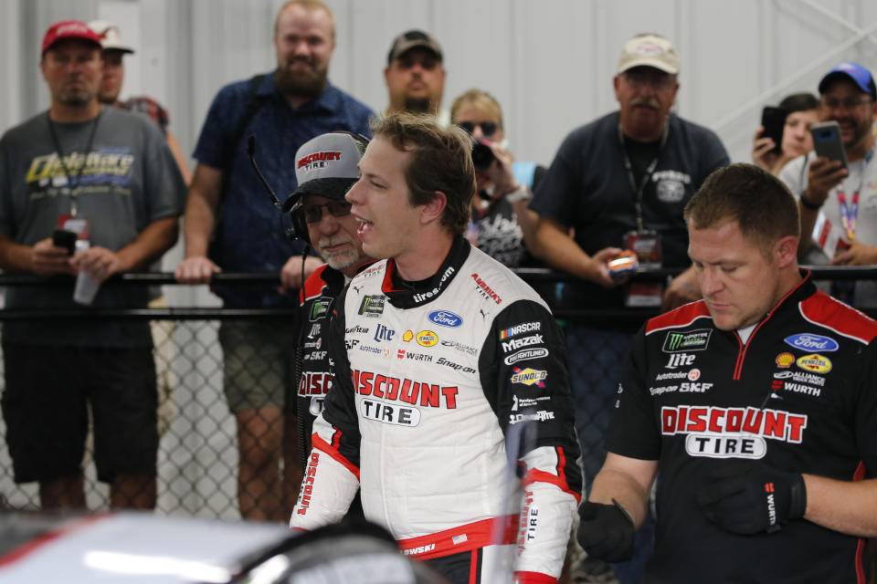 Brad Keselowski, front center, smiles in the garage after winning the pole for the NASCAR Cup Series auto race at Richmond Raceway in Richmond, Va., Friday, Sept. 20, 2019. (AP Photo/Steve Helber)