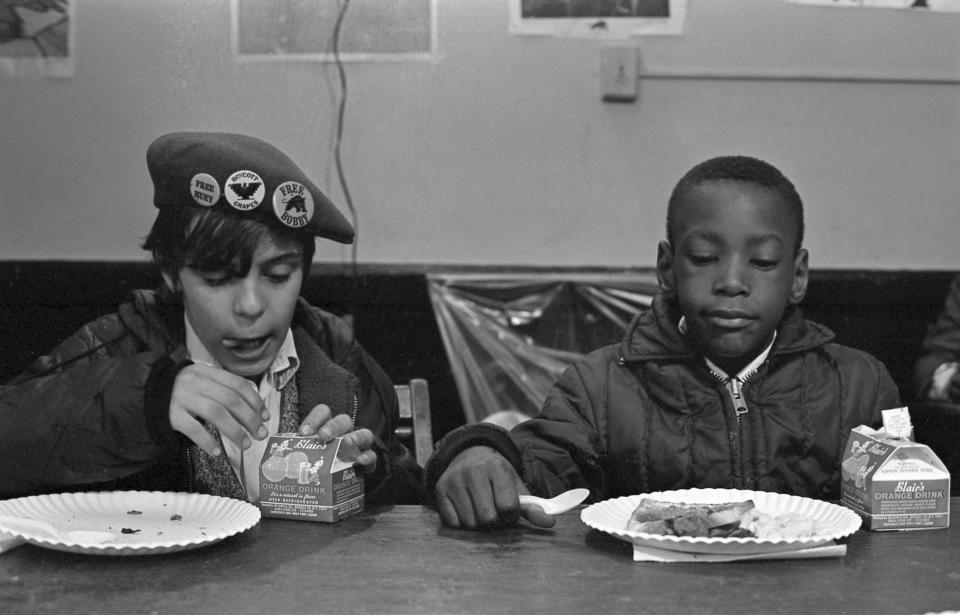 Two young boys eat during a free breakfast for children program sponsored by the Black Panther Party, New York City, winter 1969. | Getty Images