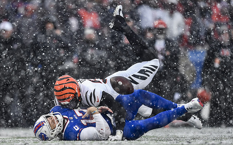 Buffalo Bills quarterback Josh Allen takes a hit from Cincinnati Bengals defensive end Joseph Ossai during the second quarter of an NFL division round game on Jan. 22 in Orchard Park, N.Y. The play was ruled an incomplete pass. <em>Associated Press/Adrian Kraus</em>