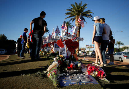 People gather to look at white crosses set up for the victims of the Route 91 Harvest music festival mass shooting in Las Vegas, Nevada, U.S., October 6, 2017. REUTERS/Chris Wattie