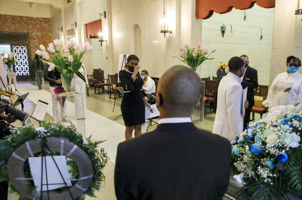 With six feet in between them, mourners pay their respects during the viewing of Joanne Paylor, 62, of Washington, inside the chapel at Cedar Hill Cemetery, in Suitland-Silver Hill, Md., Sunday, May 3, 2020. The original funeral for Paylor, who the family believes died of a heart attack, was delayed for close to two months while her family hoped social distancing guidelines would be lifted. Despite not having died from coronavirus, almost every aspect of her funeral has been impacted by the pandemic. (AP Photo/Jacquelyn Martin)