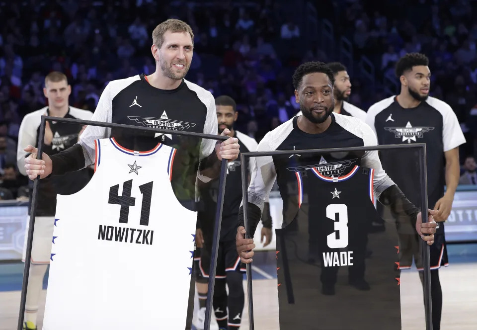 CORRECTS TO DWYANE, NOT SWAYNE - Team Giannis&#39; Dirk Nowitzki, of the Dallas Mavericks, and Team LeBron&#39;s Dwyane Wade, of the Miami Heat, are given jerseys during the second half of an NBA All-Star basketball game, Sunday, Feb. 17, 2019, in Charlotte, N.C. The Team LeBron won 178-164. (AP Photo/Chuck Burton)