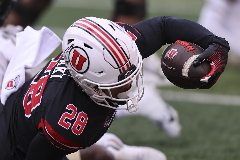 Utah running back Sione Vaki (28) stretches out the ball against Colorado during the first quarter an NCAA college football game Saturday, Nov. 25, 2023, in Salt Lake City. (AP Photo/Rob Gray)