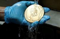 A worker from the Casa da Moeda do Brasil (Brazilian Mint) cleans a Rio 2016 Olympic medal in Rio de Janeiro, Brazil, June 28, 2016. REUTERS/Sergio Moraes