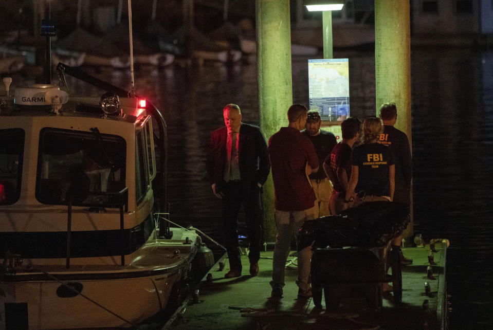 Authorities and FBI investigators cart away evidence taken from the scuba boat Conception in Santa Barbara Harbor at the end of their second day searching for the remaining divers who were missing, Tuesday, Sept. 3, 2019, in Santa Barbara, Calif. High school students, a science teacher and his daughter, an adventurous marine biologist and a family of five celebrating a birthday are among those presumed to have died when fire tore through the scuba diving boat off the Southern California coast Monday, trapping dozens of sleeping people below deck. (AP Photo/Christian Monterrosa)