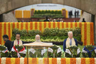 U.S. President Joe Biden, right, with Indian Prime Minister Narendra Modi and other G20 leaders, pay their respects at the Rajghat, a Mahatma Gandhi memorial, in New Delhi, India, Sunday, Sept. 10, 2023. (AP Photo/Kenny Holston, Pool)