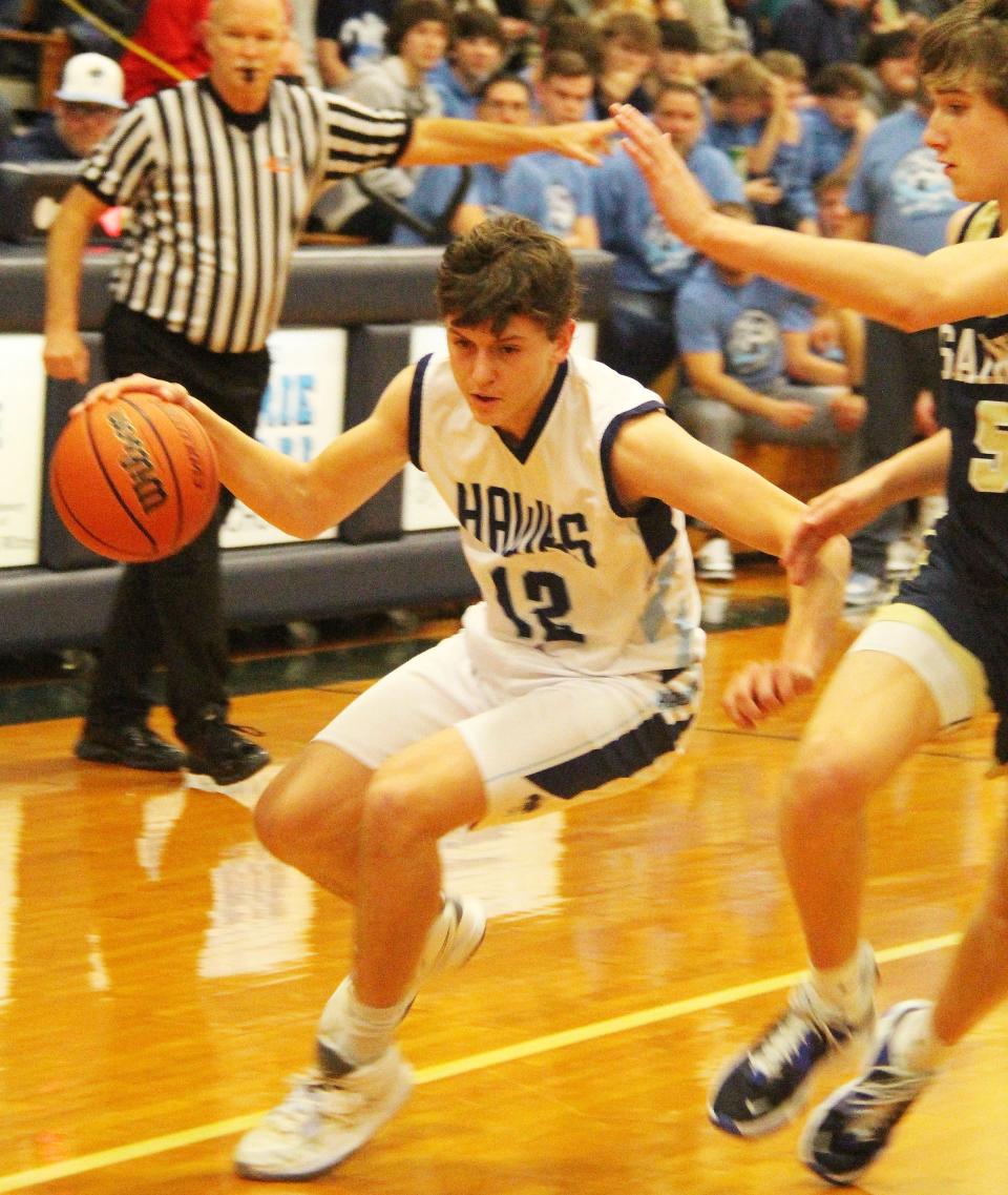 Tyler Curl of Prairie Central puts on the brakes to let Central Catholic's Cole Certa rush by during Tuesday's IPC-clinching victory for the Hawks. Curl scored 15 points in the win.