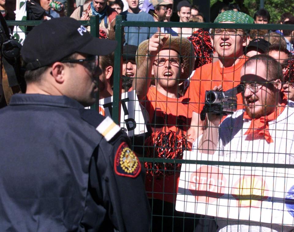 Protesters yell at police from behind a barricade after a person was arrested, Sunday June 11, 2000 in Calgary.  The protesters  were on hand to demonstrate against the World Petroleum Congress.