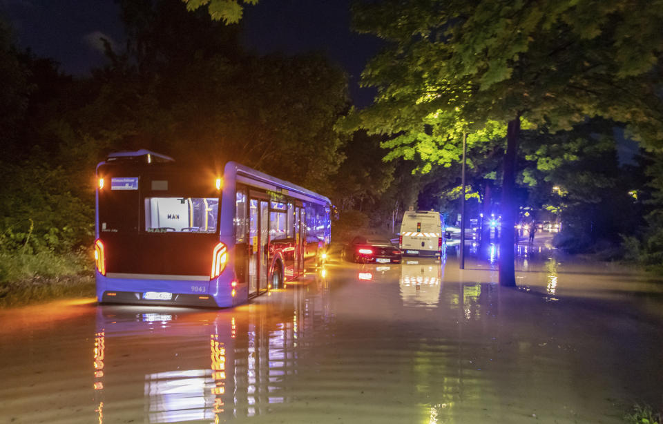 A bus stuck in water on a flooded road in Munich, Germany, Wednesday, June 23, 2021. In the evening, a storm had passed over Munich, which caused numerous fire brigade operations and flooded streets. (Andre Maerz/dpa via AP)