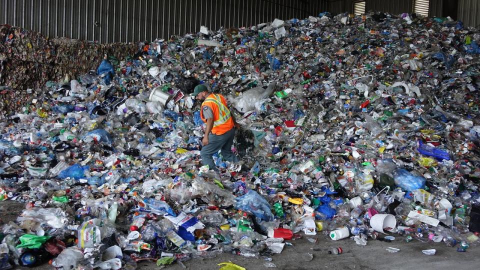 Cascades Recovery plant supervisor Jake Bennett sifts through mounds of blue box recycling delivered to the Ottawa plant, weeding out non-recyclable items.