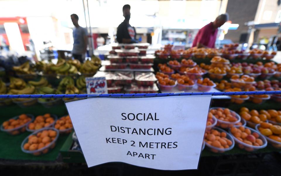 A social distancing notice at an open air market in London - Shutterstock