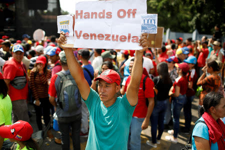 FILE PHOTO: A supporter of Venezuela's President Nicolas Maduro holds a banner during a rally in support of him in Urena, Venezuela, February 11, 2019. REUTERS/Marco Bello/File Photo