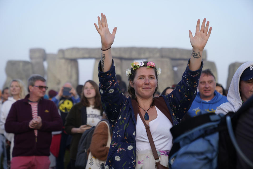 People gather during sunrise as they take part in the Summer Solstice at Stonehenge in Wiltshire, England Wednesday, June 21, 2023. (Andrew Matthews/PA via AP)