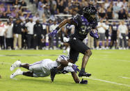 FILE - TCU running back Kendre Miller (33) runs the ball as he is tripped up by Kansas State linebacker Khalid Duke (29) during an NCAA college football game Saturday, Oct. 22, 2022, in Fort Worth, Texas. The body types are certainly much different for TCU's Kendre Miller and Kansas State's 5-foot-6 dynamo Deuce Vaughn. And yet the running backs that will be featured in the Big 12 championship game look pretty similar in what they do on the field. (AP Photo/Richard W. Rodriguez, File)