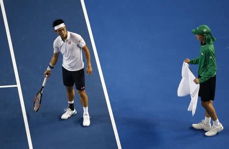 Japan's Kei Nishikori disputes a line call as a ball boy waits with a towel during his fourth round match against France's Jo-Wilfried Tsonga at the Australian Open tennis tournament at Melbourne Park, Australia, January 24, 2016. REUTERS/Jason Reed