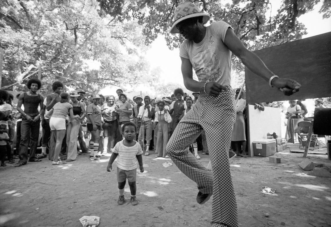 A group of people are seen dancing to music at Sycamore Park in Fort Worth during Juneteenth festivities in 1977