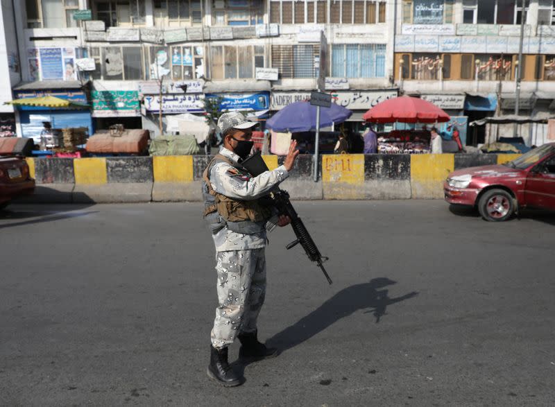 An Afghan policeman stands guard at a check point in Kabul, Afghanistan