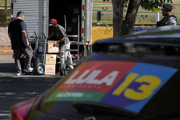 Trabajadores electorales bajan las máquinas de votación frente a un centro electoral, en Brasilia