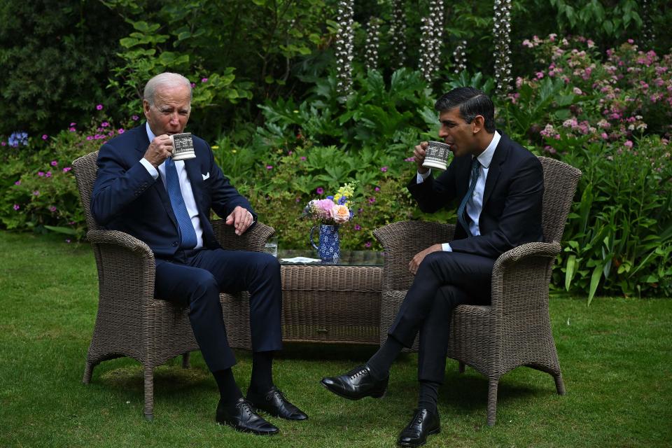 Britain's Prime Minister Rishi Sunak and US President Joe Biden drink ffrom mugs as they sit in the garden of 10 Downing Street (AFP via Getty Images)