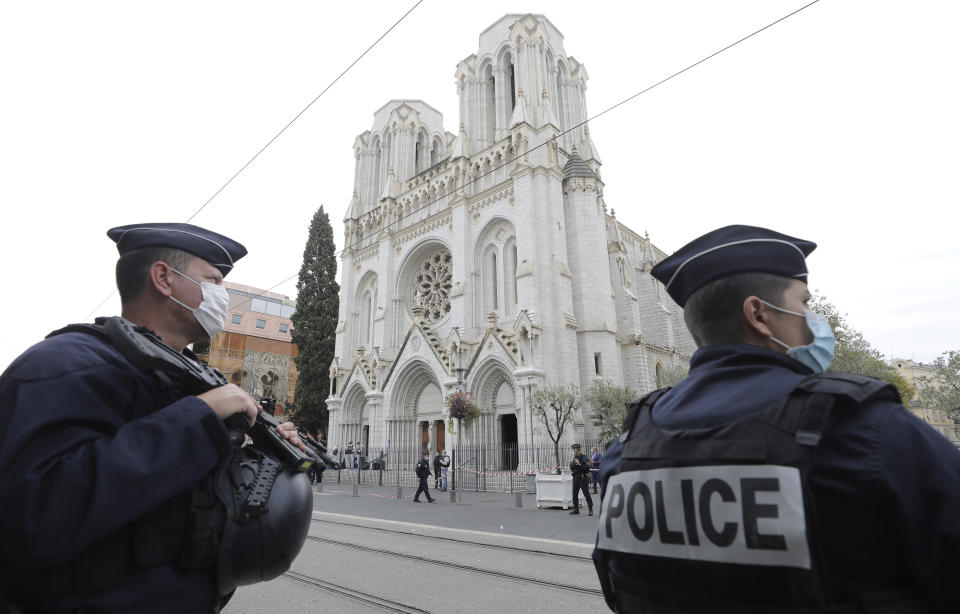 Police officers stand guard near Notre Dame church in Nice, southern France, Thursday, Oct. 29, 2020. An attacker armed with a knife killed at least three people at a church in the Mediterranean city of Nice, prompting the prime minister to announce that France was raising its security alert status to the highest level. It was the third attack in two months in France amid a growing furor in the Muslim world over caricatures of the Prophet Muhammad that were re-published by the satirical newspaper Charlie Hebdo. (Eric Gaillard/Pool via AP)