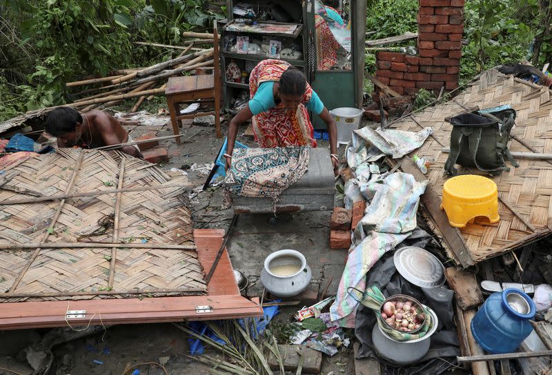 Residents salvage their belongings from the rubble of a damaged house in the aftermath of Cyclone Amphan, in South 24 Parganas