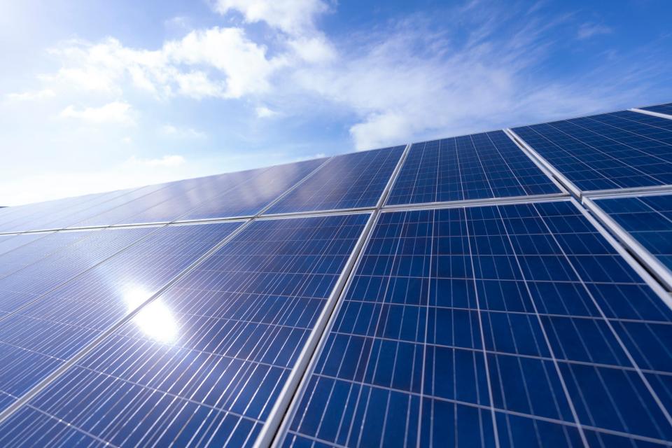 Solar panels under a bright blue sky.