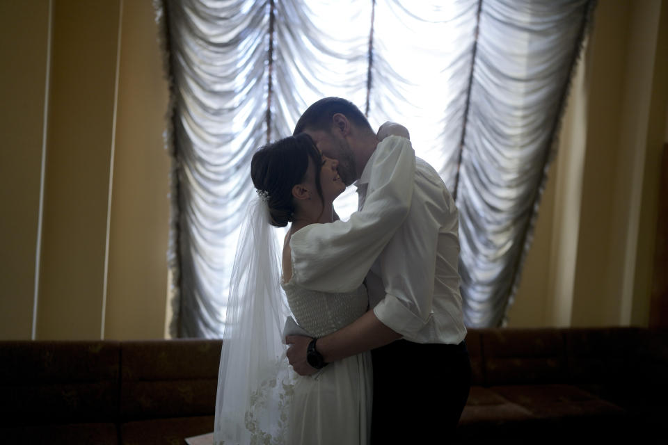 Kateryna Lytvynenko and Ihor Zakvatskyi embrace after getting married in Kyiv, Ukraine, Wednesday, June 15, 2022. Ihor proposed to Kateryna on the day the war started. A growing number of couples in Ukraine are speedily turning love into matrimony because of the war with Russia. Some are soldiers, marrying just before they head off to fight. Others are united in determination that living and loving to the full are more important than ever in the face of death and destruction. (AP Photo/Natacha Pisarenko)