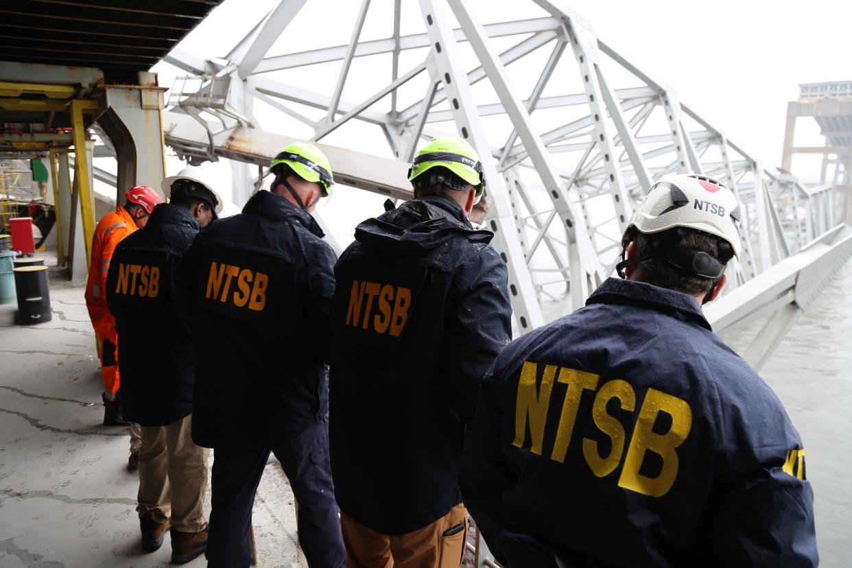 NTSB investigators are seen March 27, 2024, on the cargo vessel Dali, which struck and collapsed the Francis Scott Key Bridge on March 26, 2024.