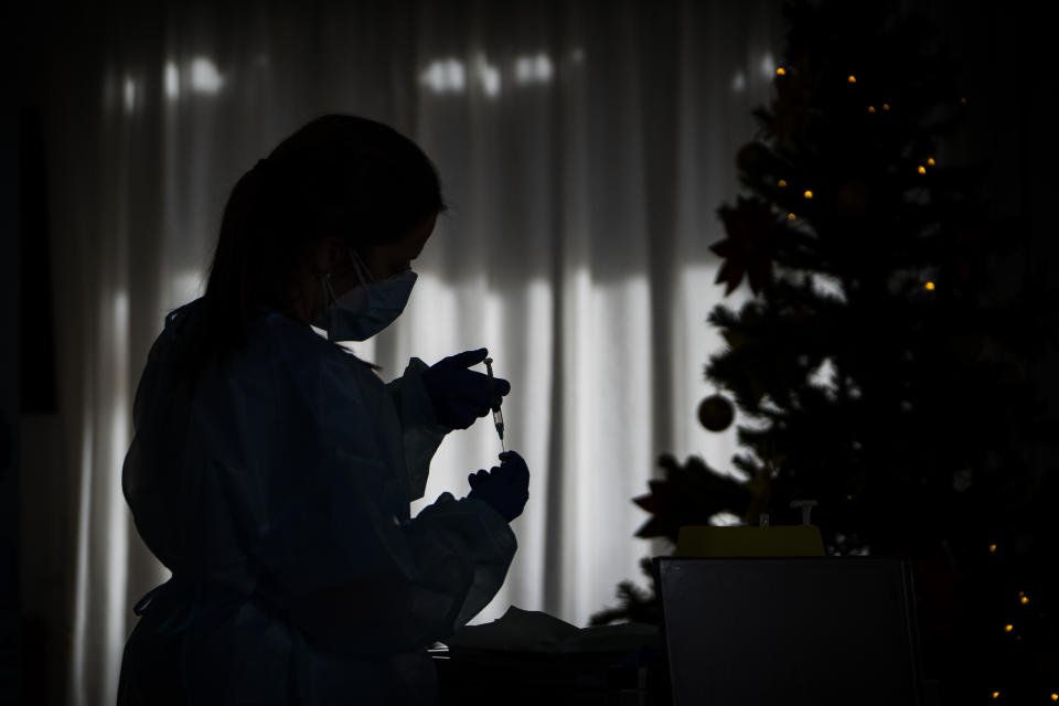 Nurse Idoia Crespo prepares a vaccine against the Coronavirus at a nursing home in l'Hospitalet de Llobregat in Barcelona, Spain, on Sunday, Dec. 27, 2020. The first shipments of coronavirus vaccines developed by BioNTech and Pfizer have arrived across the European Union, authorities started to vaccinate the most vulnerable people in a coordinated effort on Sunday. (AP Photo/Emilio Morenatti)