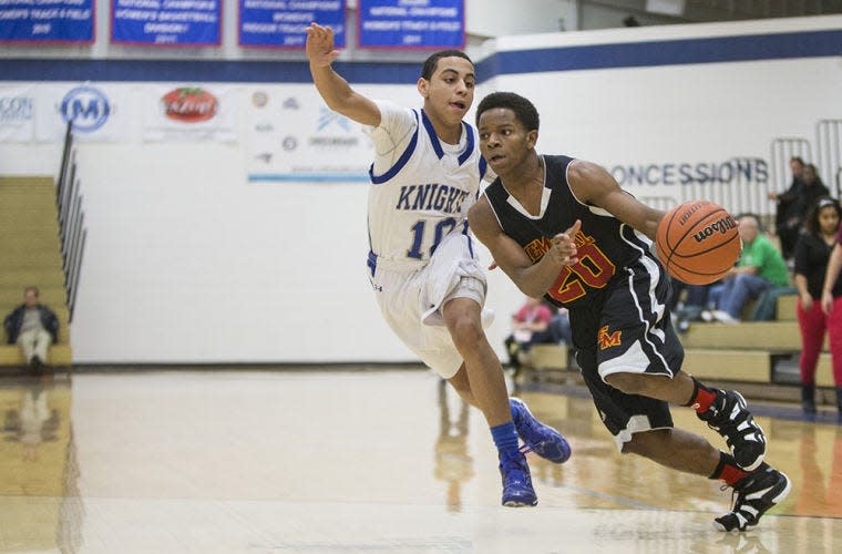 Elkhart Memorial's Deante Dalton, right, drives by Marian's Julian Hubbard during the first game of the NIC/NLC Shootout boys basketball classic between Marian and Elkhart Memorial on Friday, Dec. 27, 2013, at Bethel College in South Bend. SBT Photo/ROBERT FRANKLIN