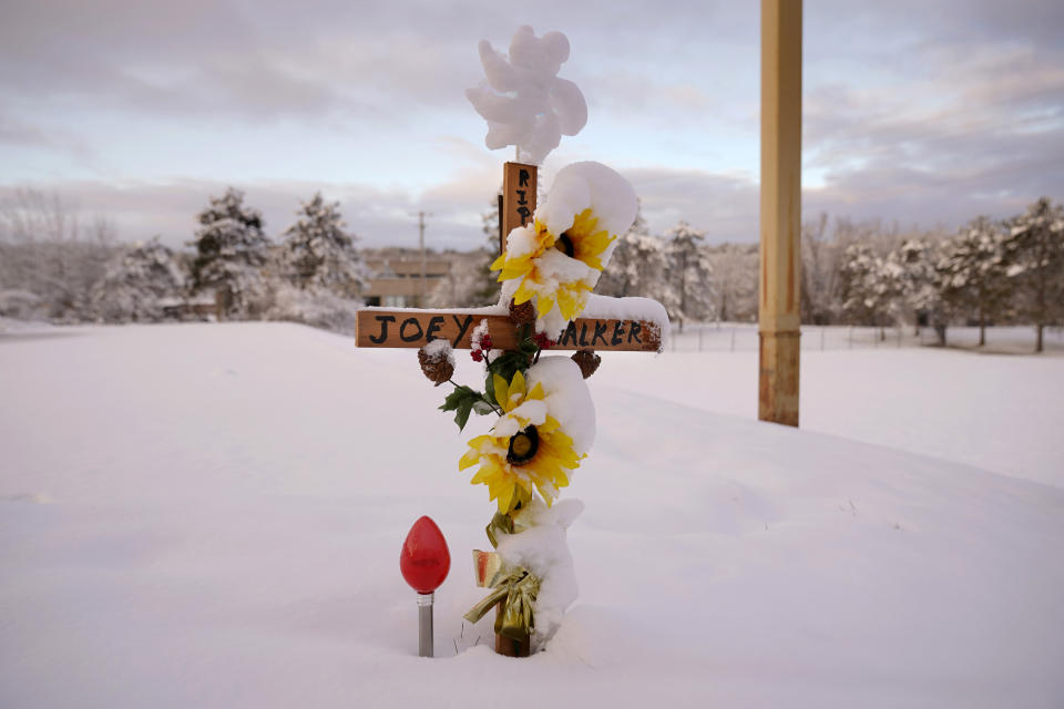 A cross marking one of the victim's of last month's mass shooting is coated with snow, Tuesday, Dec. 5, 2023, at a makeshift memorial in Lewiston, Maine. With winter approaching, officials began removing memorials to the 18 people killed. Items will be preserved at a local museum. (AP Photo/Robert F. Bukaty)